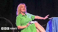 Liz Truss leaves stage as lettuce banner unfurls